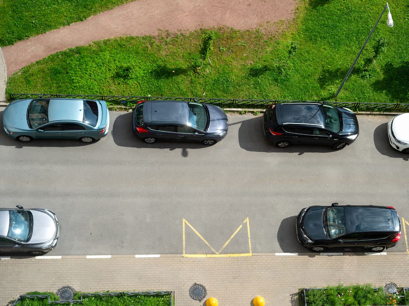 Luchtfoto van geparkeerde auto's in een straat.