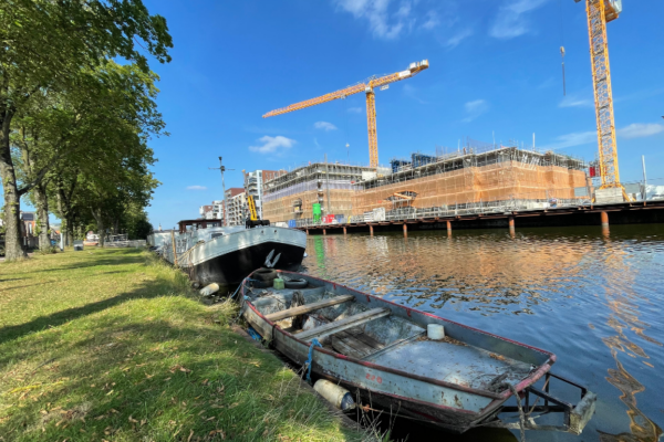 Bootjes in het Noordhollands Kanaal waar aan de overzijde woningen worden gebouwd.